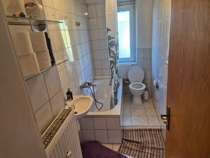 Ett badrum med badkar, toalett och handfat.