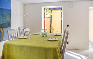 En matplats med ett bord dukat för fyra personer, stolar, en grön duk och en kanna.