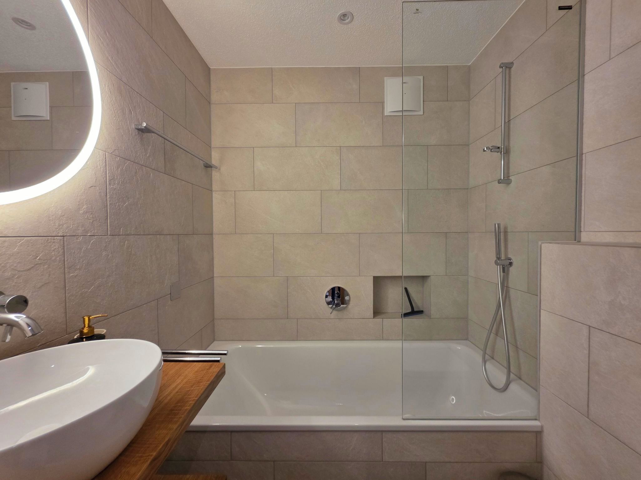 A modern bathroom with a bathtub, a sink, and a shower.