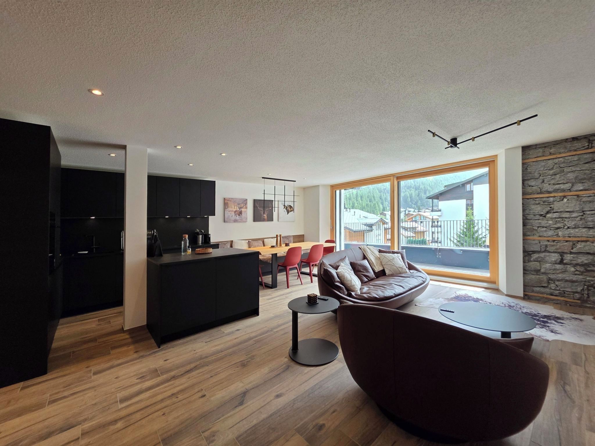 A modern living space with a kitchen, dining area, and seating area.
