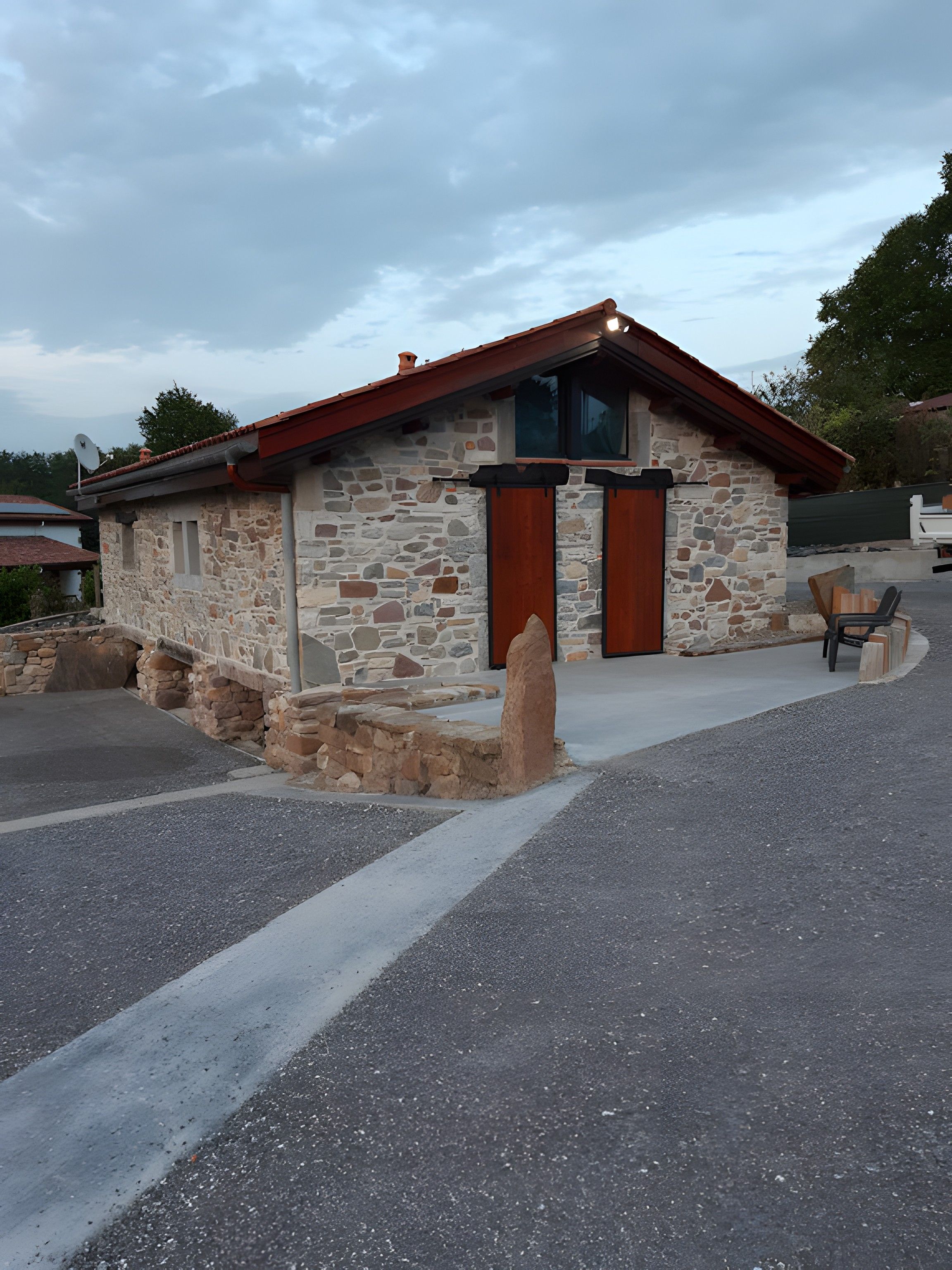 Un edificio in pietra con tetto rosso e un'unica porta d'ingresso.