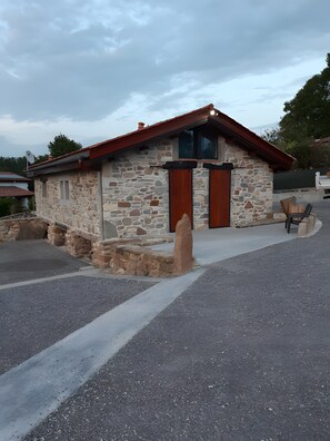 A stone building with a red roof and a single entrance door. - Holiday Home "Maison Gau Argi2" with Wi-Fi (Armendarits)