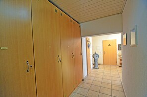 Ein Flur mit Holfachschränken, einem Manometer und einer Tür zu einem weiteren Raum.