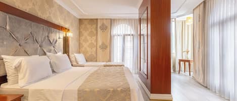 A hotel room with a large bed, a wooden headboard, and a view of the hallway.