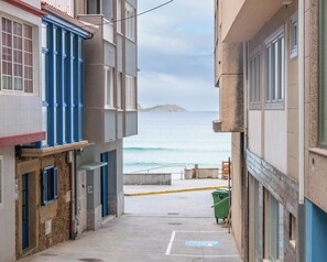 Eine schmale Gasse mit Häusern an beiden Seiten, die zu einem Blick auf das Meer führt.
