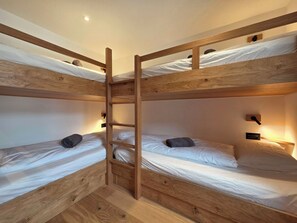 A bunk bed room with wooden frames, white bedding, and a wall-mounted light fixture. - Du Glacier B3 Appartement/Fewo Appartement/Fewo by Interhome (Saas-Fee)