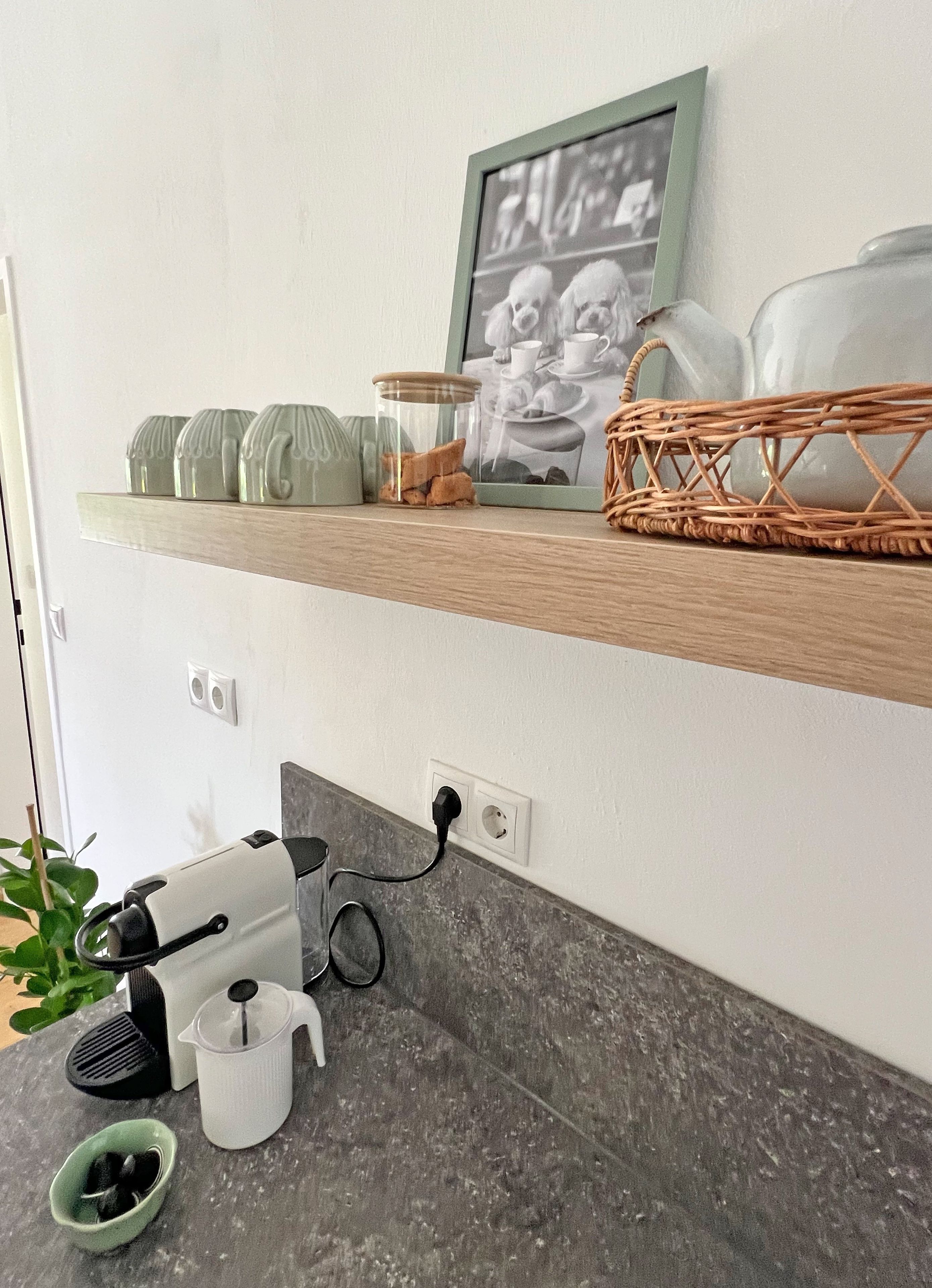 Eine Küchenarbeitsplatte mit Kaffeemaschine, Wasserkocher und Tasse.