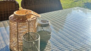 A glass-top table with wicker chairs and a basket.