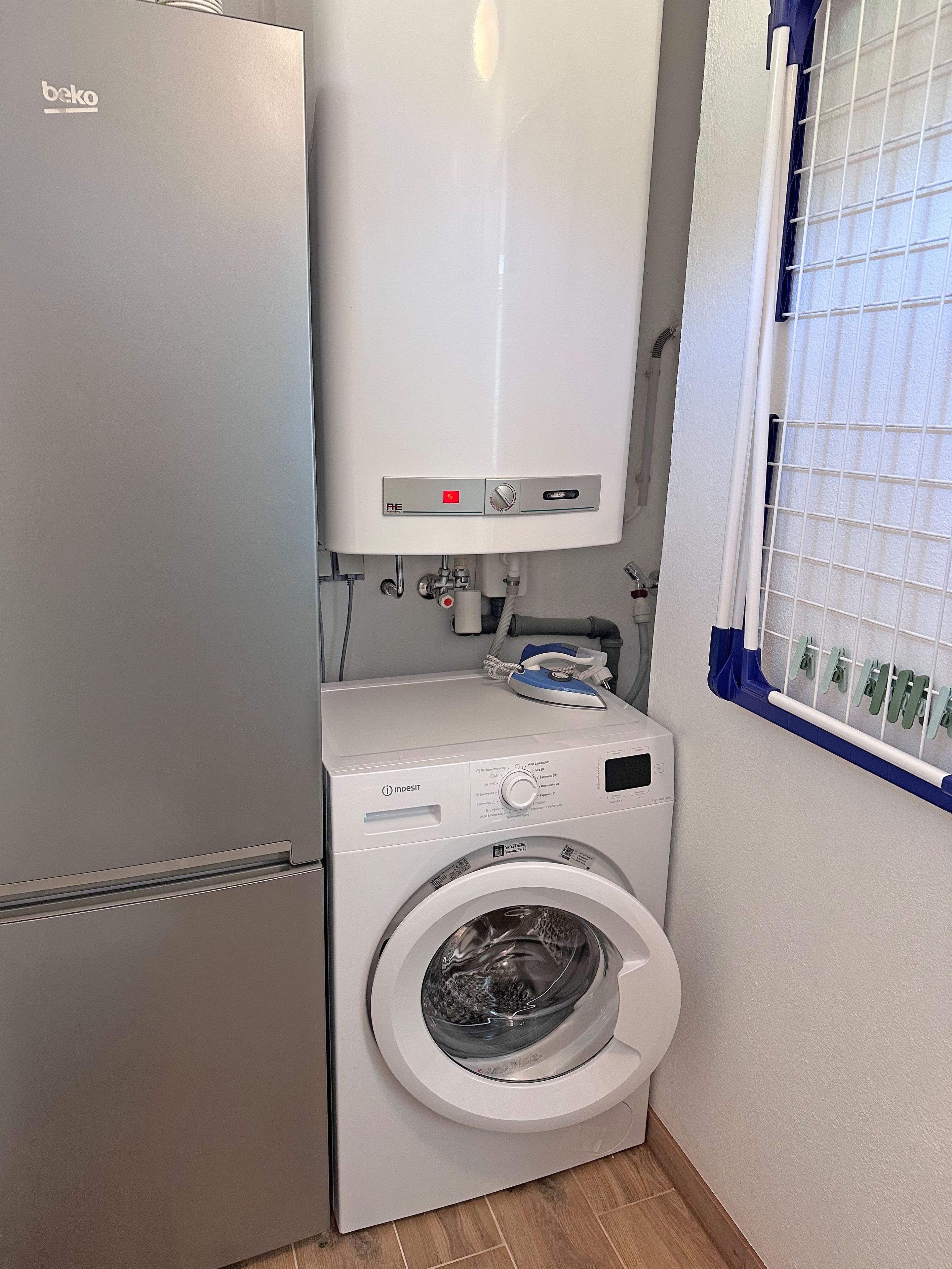 Ein kleiner Waschbereich mit Waschmaschine und integriertem Heizgerät.