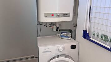 Ein kleiner Waschbereich mit Waschmaschine und integriertem Heizgerät.