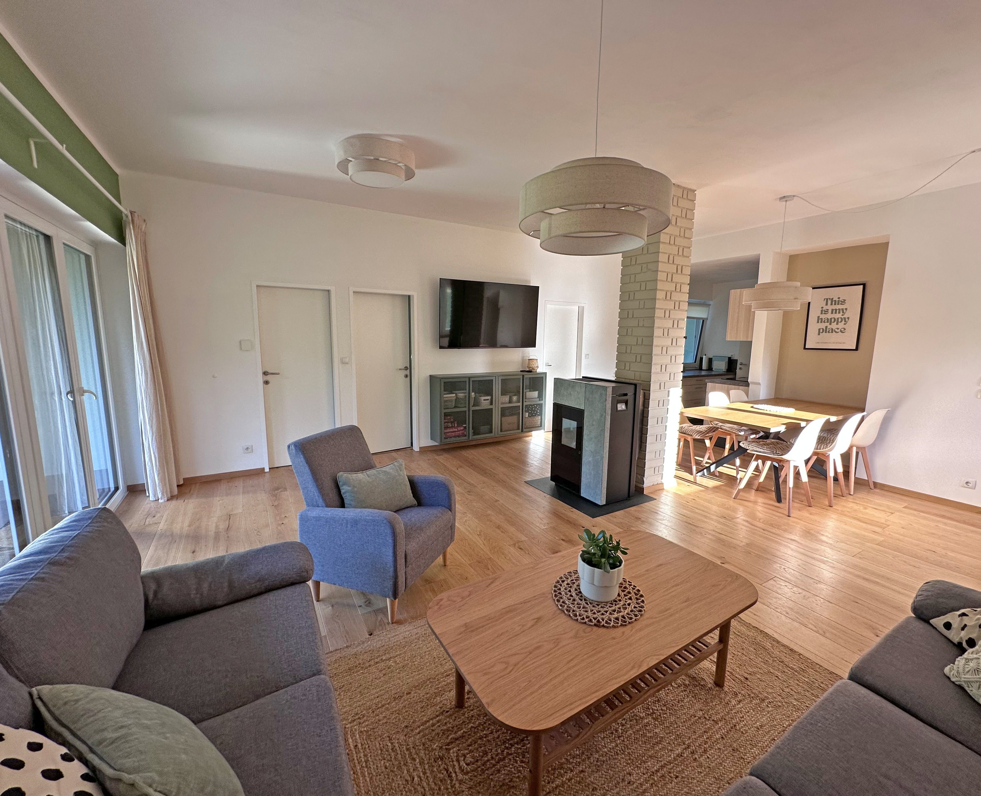 A modern living room with a sofa set, a coffee table, and a TV.