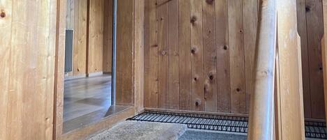 Interior de madera con un cuadro enmarcado en la pared, una puerta y un suelo alfombrado.