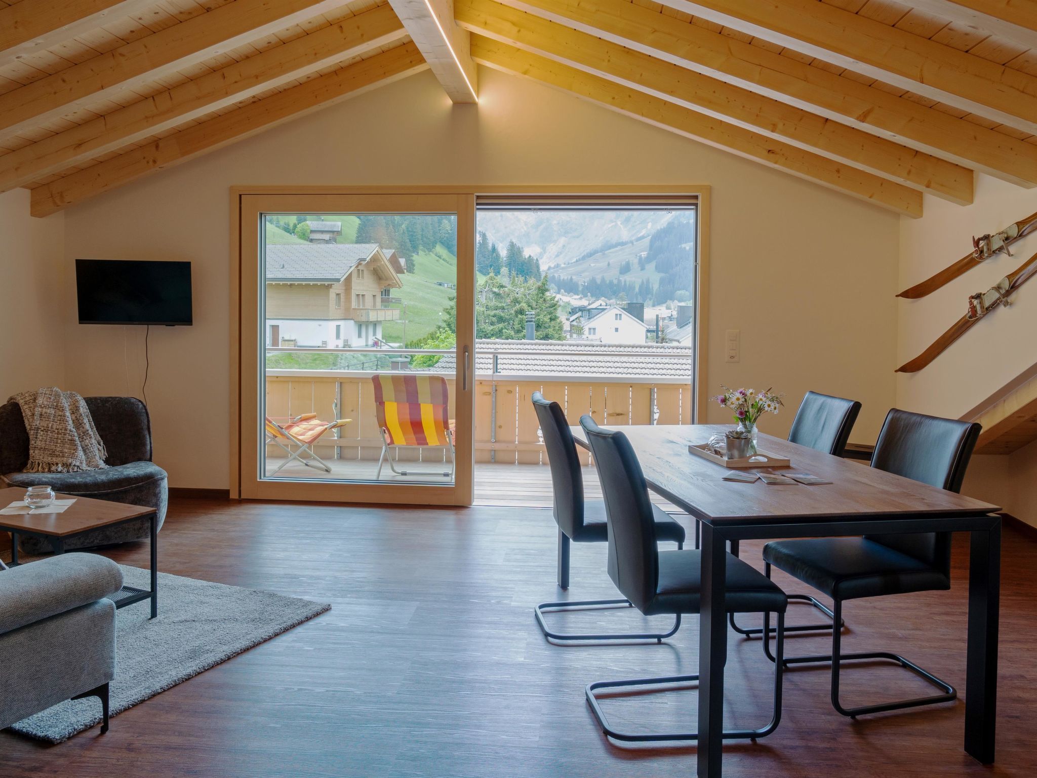 A spacious room with a dining area, a sofa, and a television.