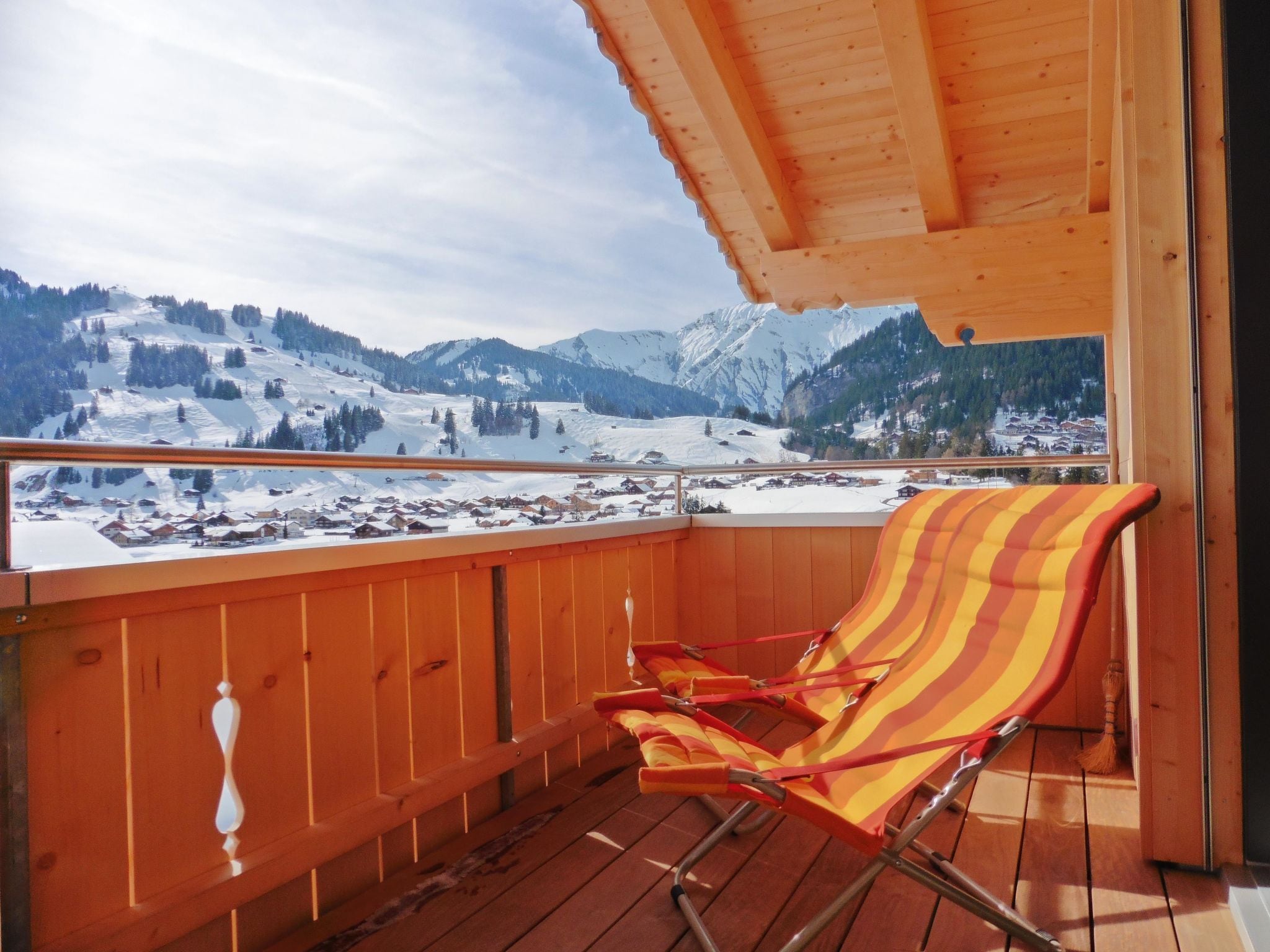 A wooden deck with a view of snow-covered mountains.