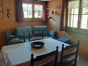 En matplats med ett bord, stolar och en skål på bordet.