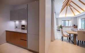 A modern kitchen with a built-in oven, a wooden cabinet, and a white countertop.