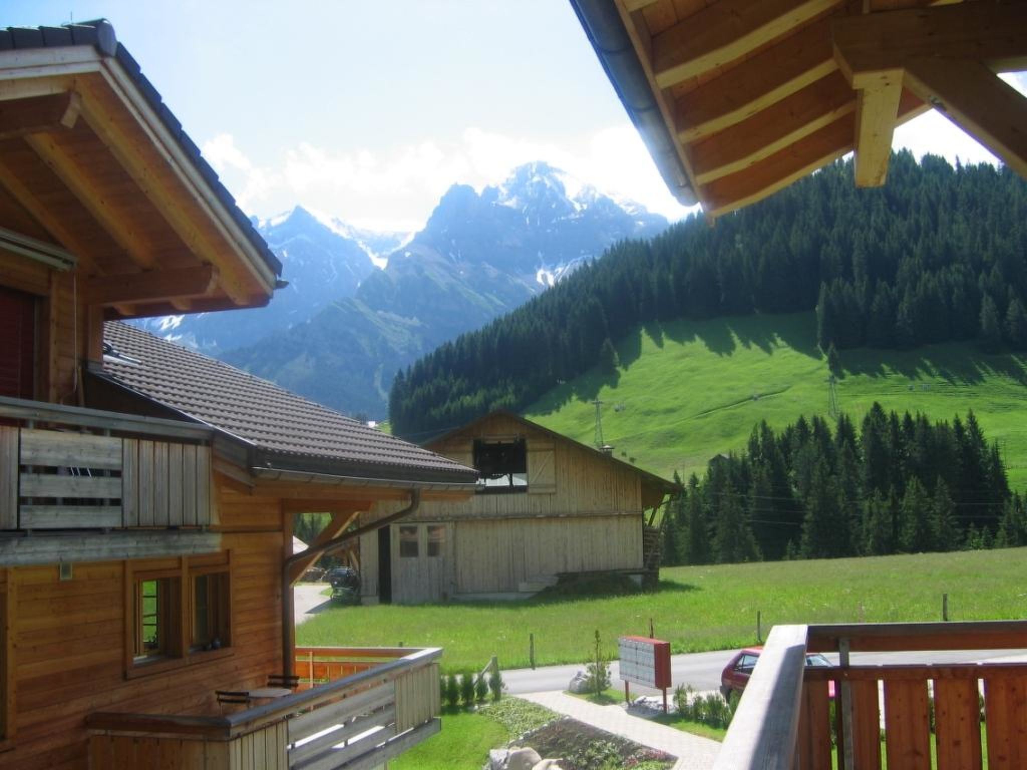 A wooden cabin with a balcony overlooking a mountainous landscape.