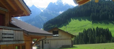 A wooden cabin with a balcony overlooking a mountainous landscape.
