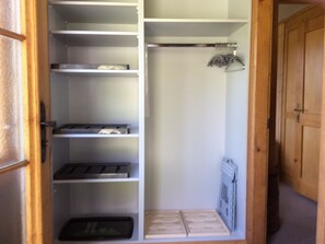 A walk-in closet with open shelves, a hanging rack, and a radiator. - Bärgrose Appartement/Fewo, Bad, WC, 3 Schlafräume 4-Zimmerwohnung by Interhome (Adelboden)
