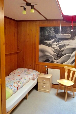 A room with a wooden bunk bed, a desk, a chair, and a large window with a snowy landscape view. - Bärgrose Appartement/Fewo, Bad, WC, 3 Schlafräume 4-Zimmerwohnung by Interhome (Adelboden)