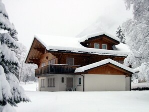 A two-story wooden chalet with a snow-covered roof and surrounding trees. - Chalet im Ahori Appartement/Fewo, Dusche oder Bad, WC 3-Zimmerwohnung by Interhome (Kandersteg)