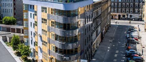 Un edificio de varios pisos con un diseño arquitectónico moderno, que presenta una fachada curva y ventanas amplias.