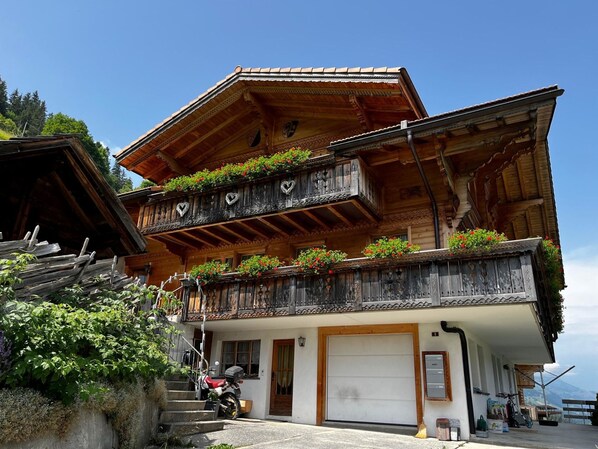 A traditional chalet with wooden balconies, a garage, and a mountain view. - Elim Appartement/Fewo, Bad, WC, 4 oder mehr Schlafräume 5.5 Zimmerwohnung by Interhome (Adelboden)