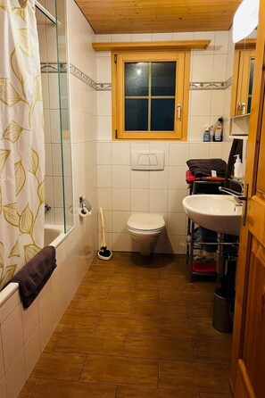 Un baño con bañera, inodoro y lavabo.