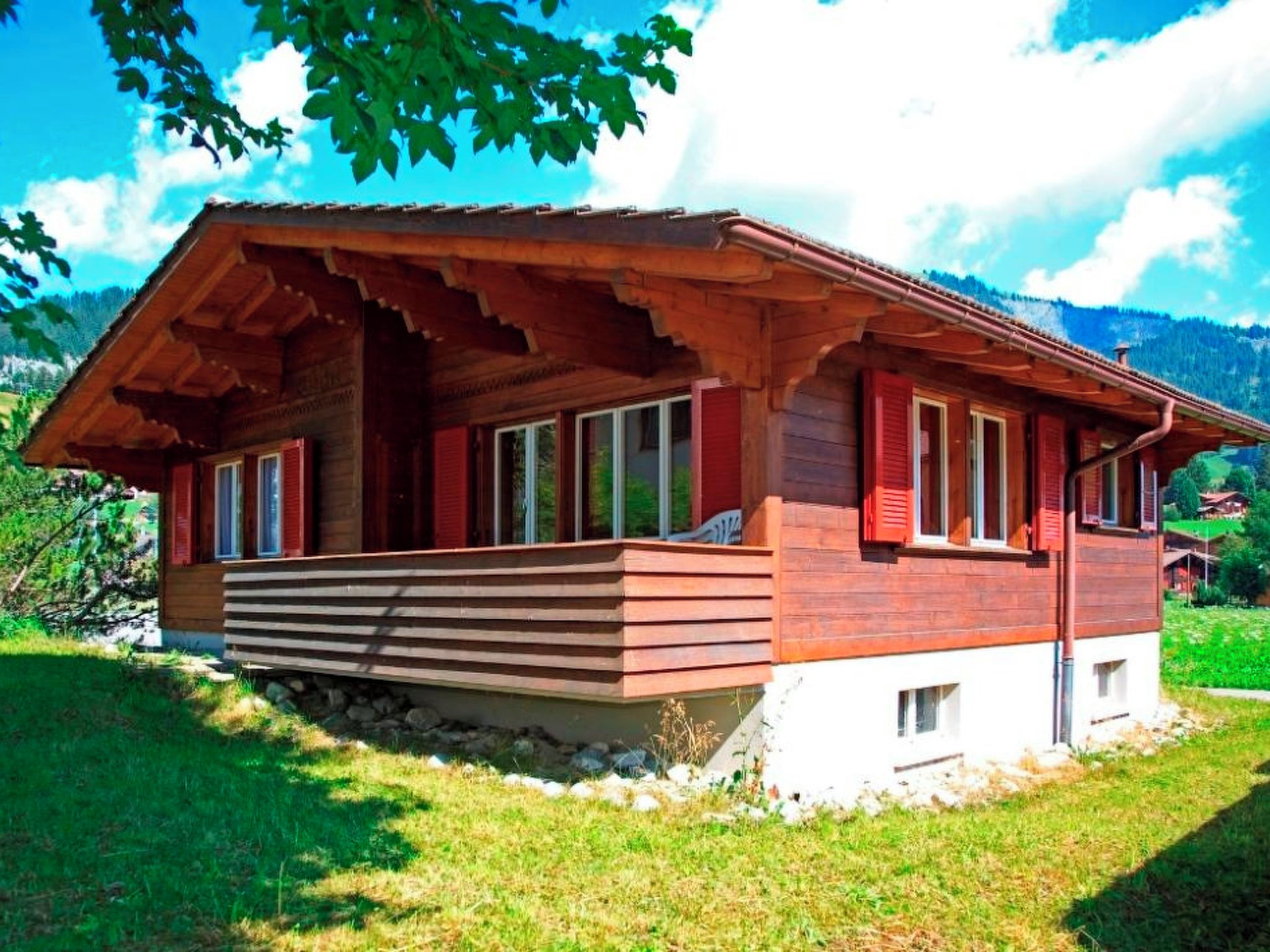 Eine Holzhütte mit geneigtem Dach, einer Veranda und einem Steinfundament.