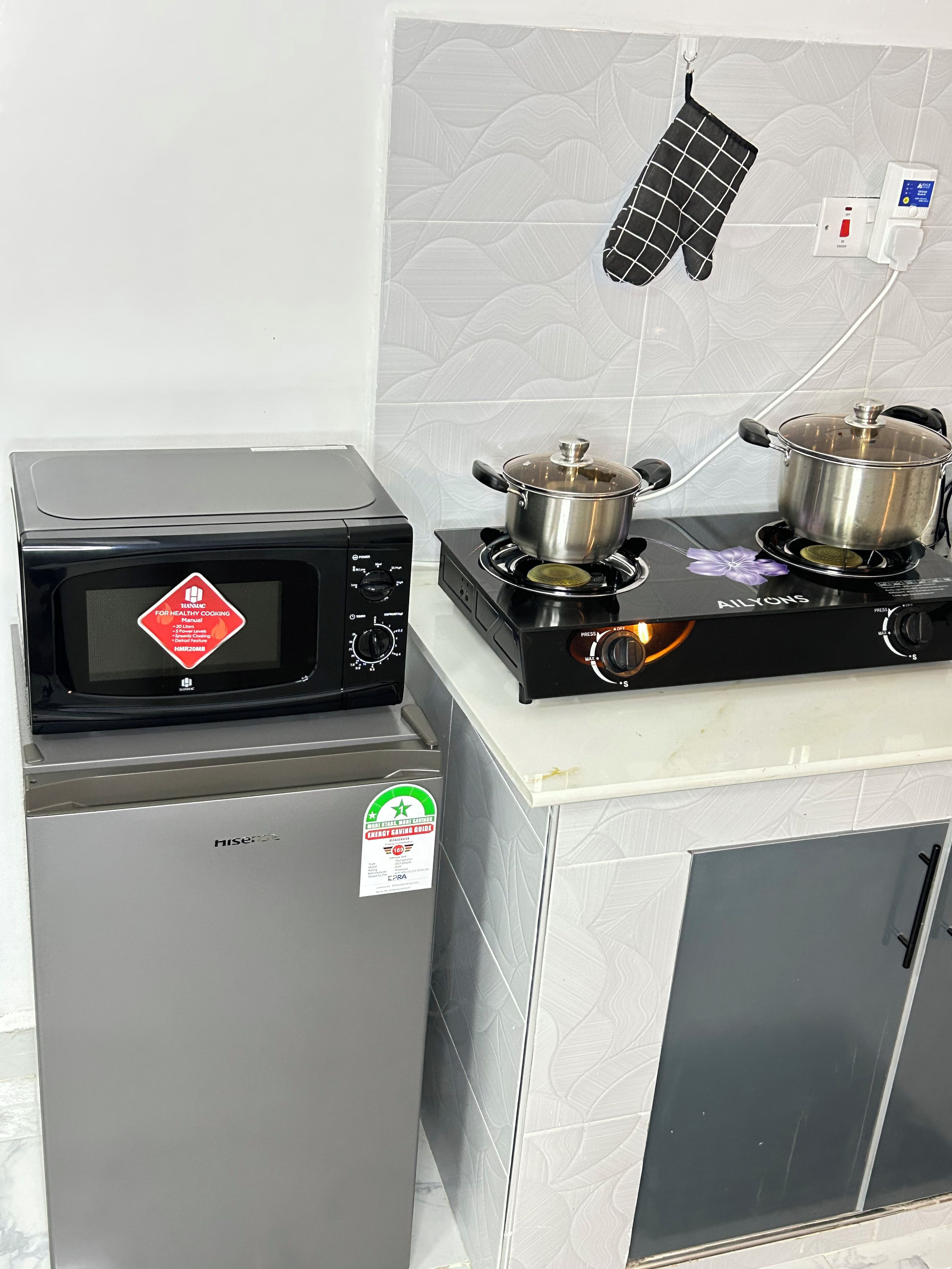 Una cuina amb microones, fogó i nevera.