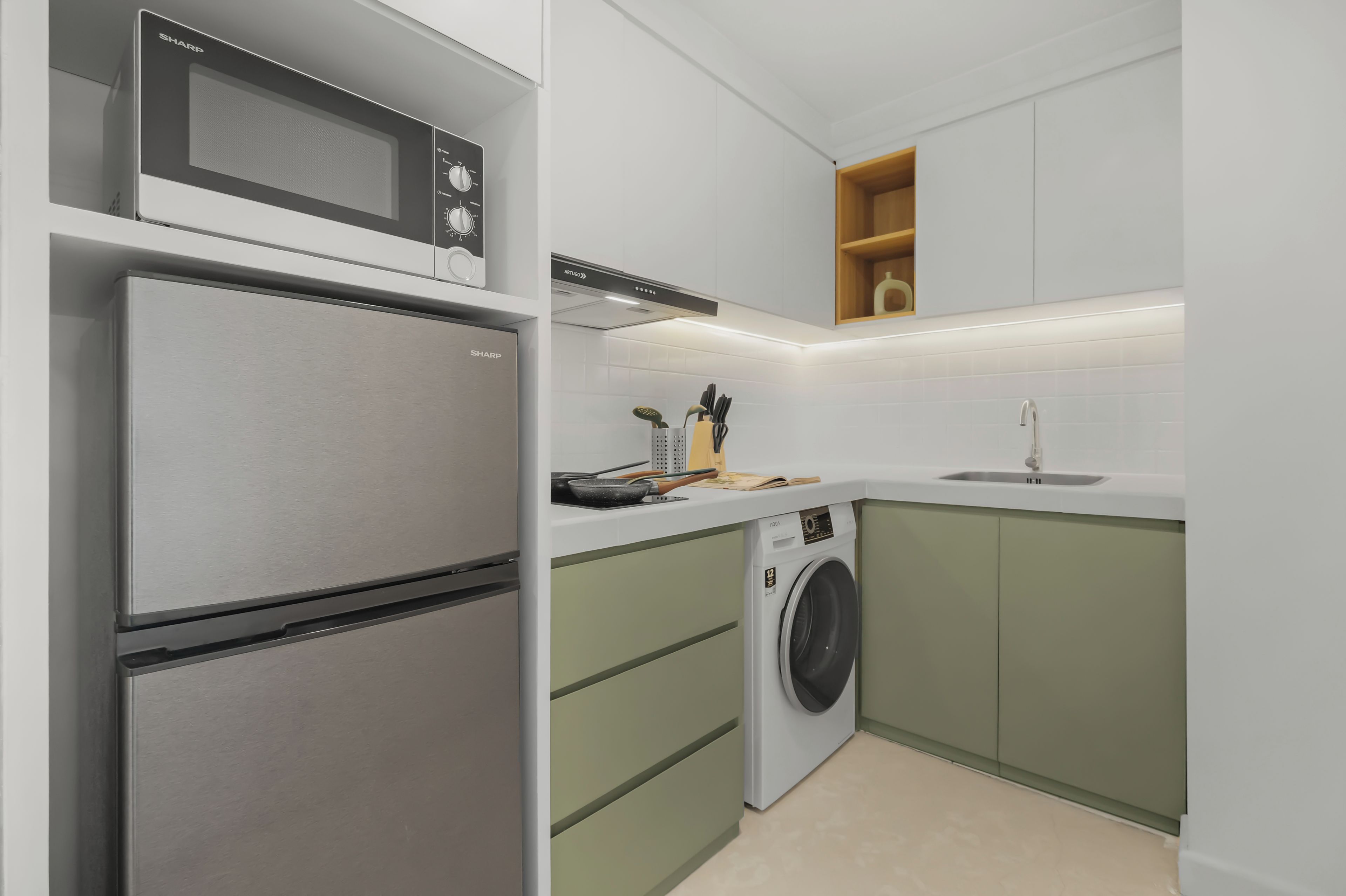 Cocina compacta con refrigerador, microondas y lavadora.