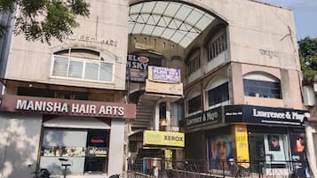 A building with multiple storefronts including Manisha Hair Arts, Hotel Plan Sky, and Lawrence & Mayo.