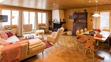 Un salon chaleureux avec une cheminée, des meubles en bois et un coin repas.