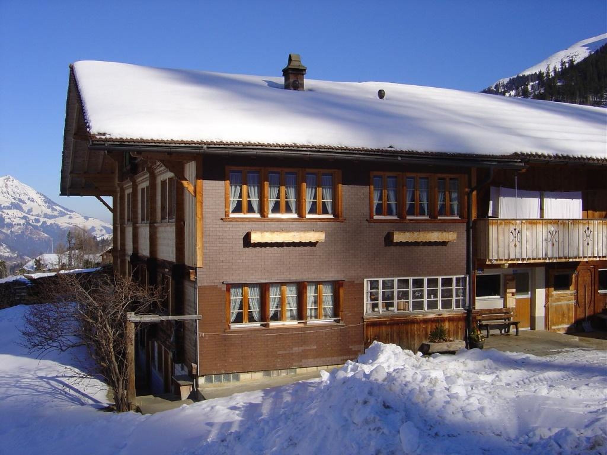 A two-story building with multiple windows and a snow-covered roof, surrounded by a snowy landscape.