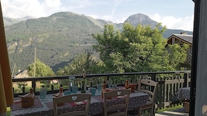 A balcony with a table set for dining, overlooking a mountainous landscape. - HARMONIE ROOM FOR 4 PEOPLE (Auris)