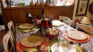 A dining table set with plates, cutlery, and a hot pot centerpiece. - HARMONIE ROOM FOR 4 PEOPLE (Auris)