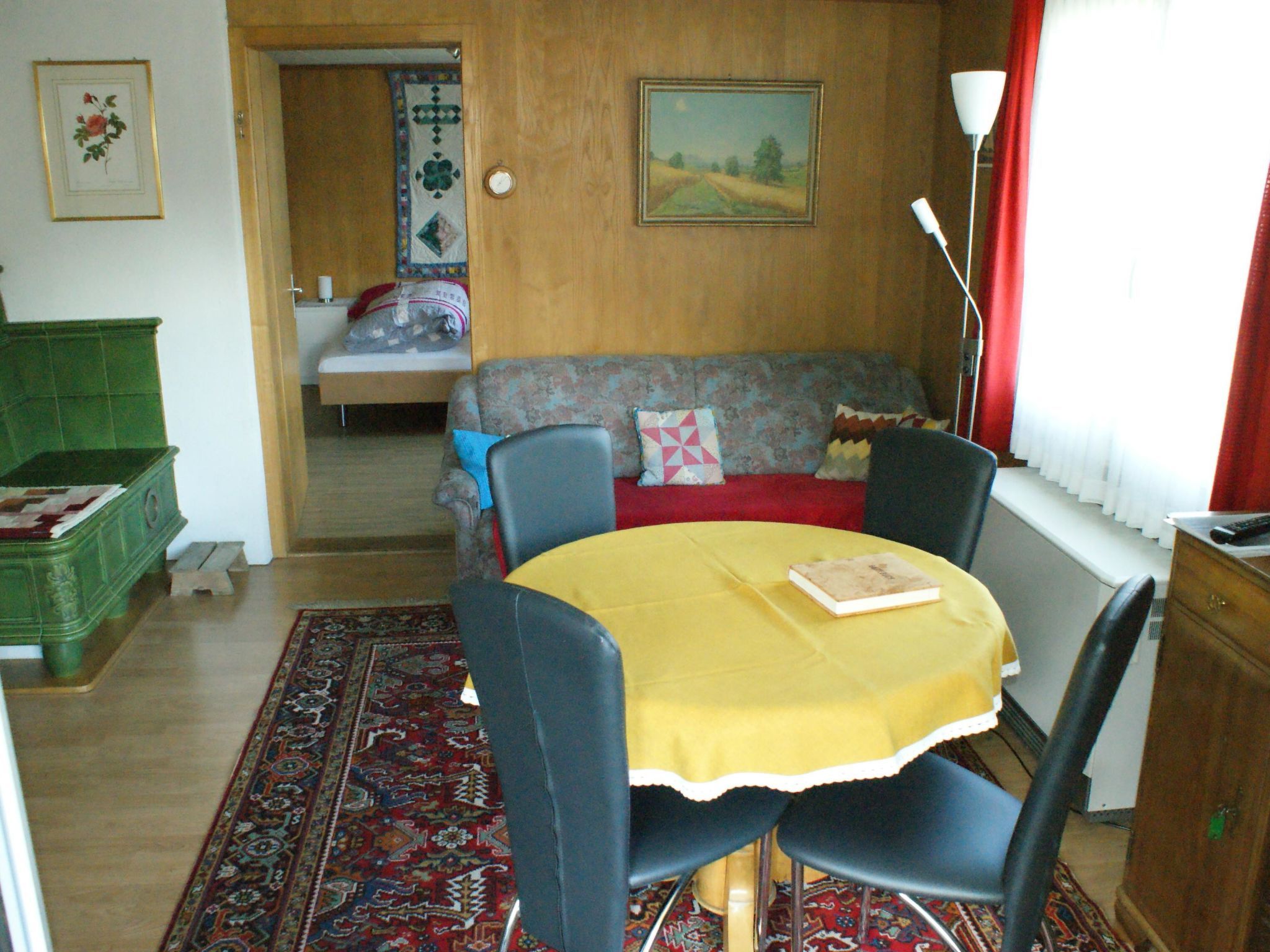A dining area with a table, chairs, and a sofa.