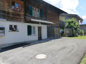 Ein zweistöckiges Gebäude mit überdachtem Eingang und Garage.