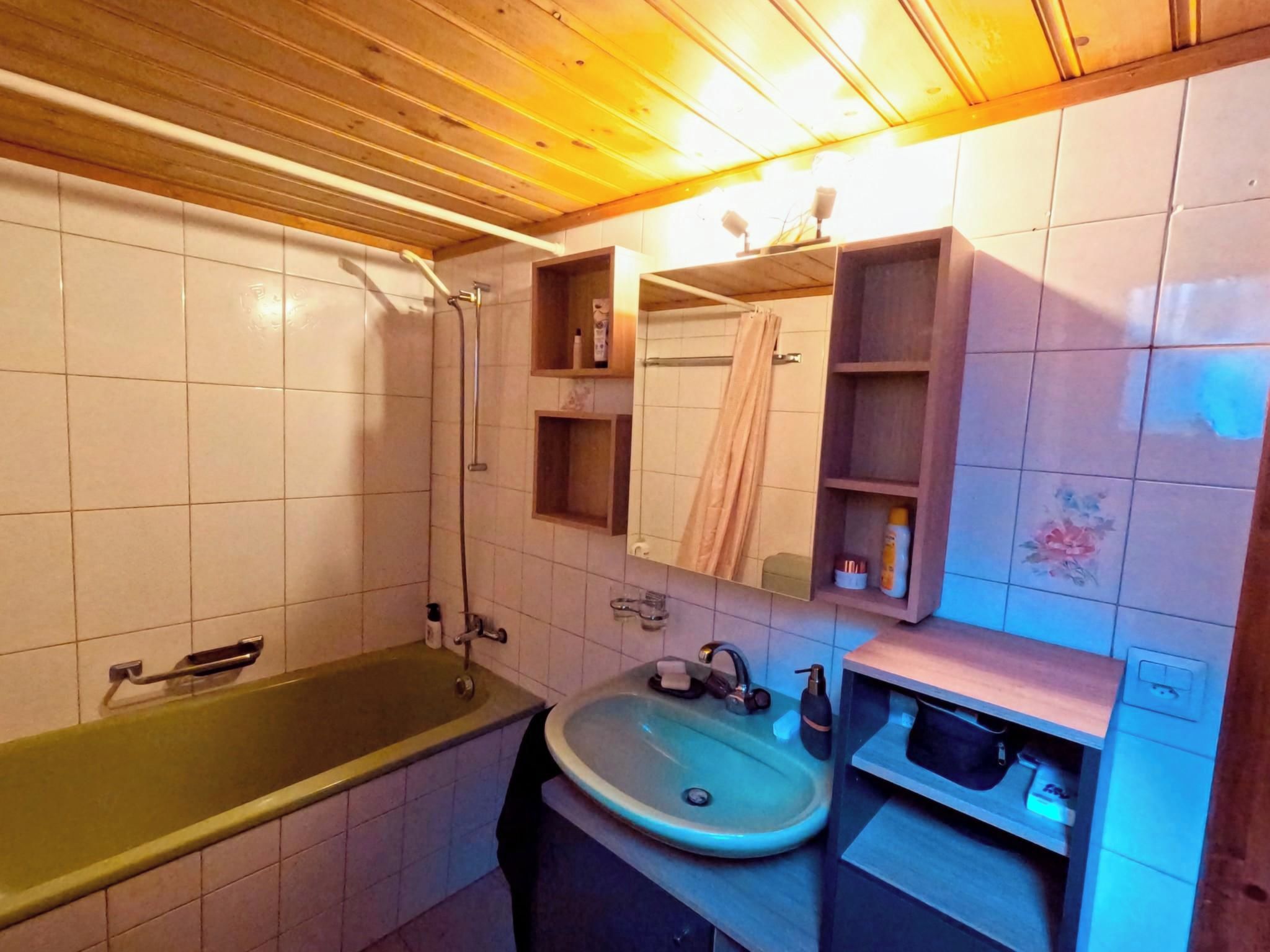 Une salle de bain avec une baignoire, un lavabo et un miroir.