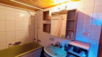 Une salle de bain avec une baignoire, un lavabo et un miroir.