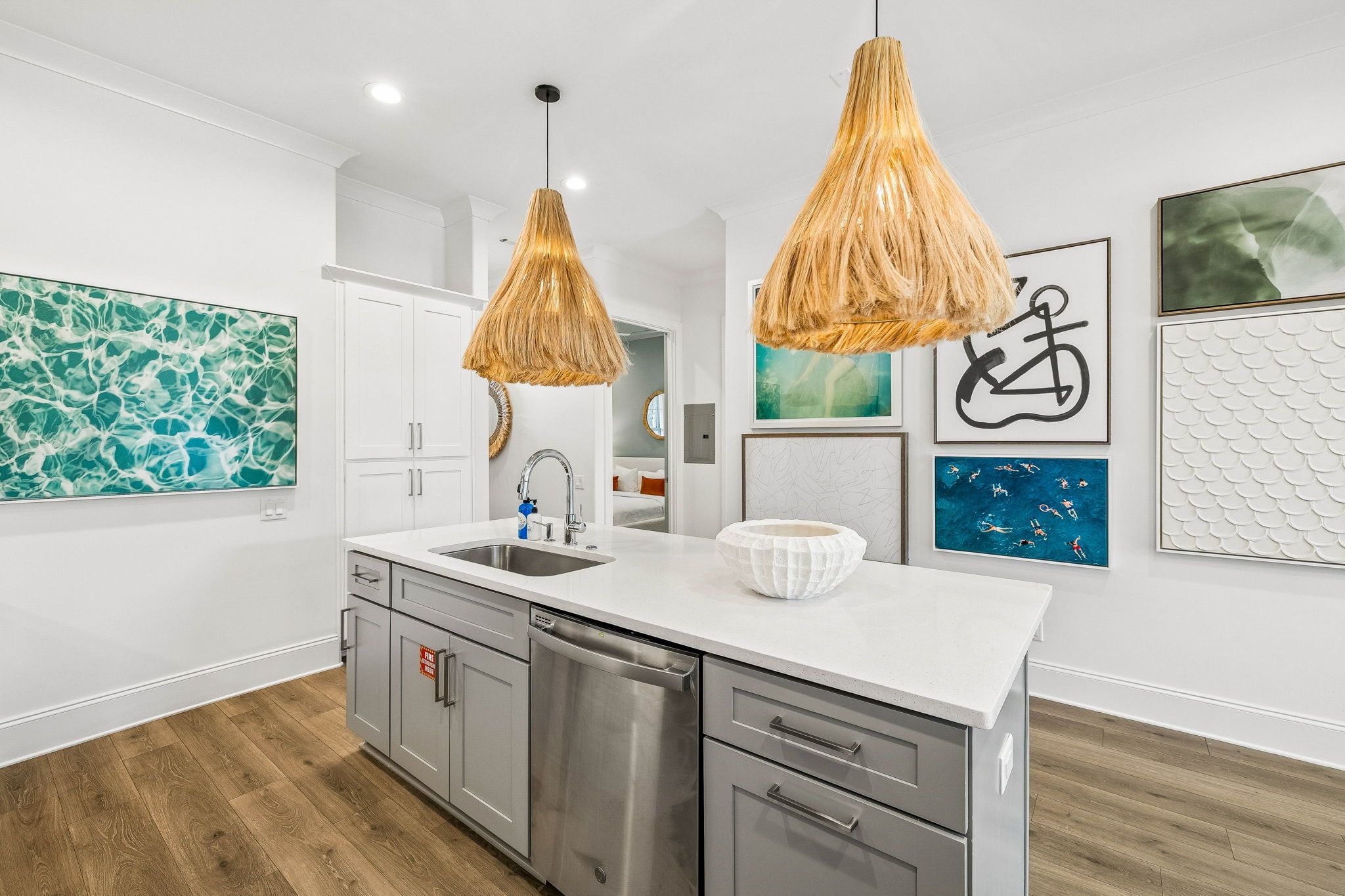 A modern kitchen with a central island, stainless steel appliances, and a white countertop.