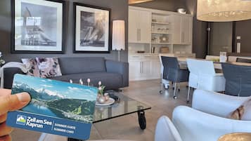 Een moderne woonkamer met een bank, salontafel en kunstwerk aan de muur.