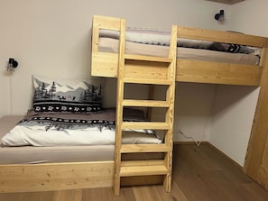 A bunk bed with a wooden ladder, a pillow with a mountain design, and a wall-mounted lamp. - Haus Bettina Appartement/Fewo, Dusche, WC, 4 oder mehr Schlafräume by Interhome (Adelboden)
