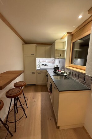 A compact kitchen with a wooden countertop, a built-in stove, and a window. - Haus Bettina Appartement/Fewo, Dusche, WC, 4 oder mehr Schlafräume by Interhome (Adelboden)