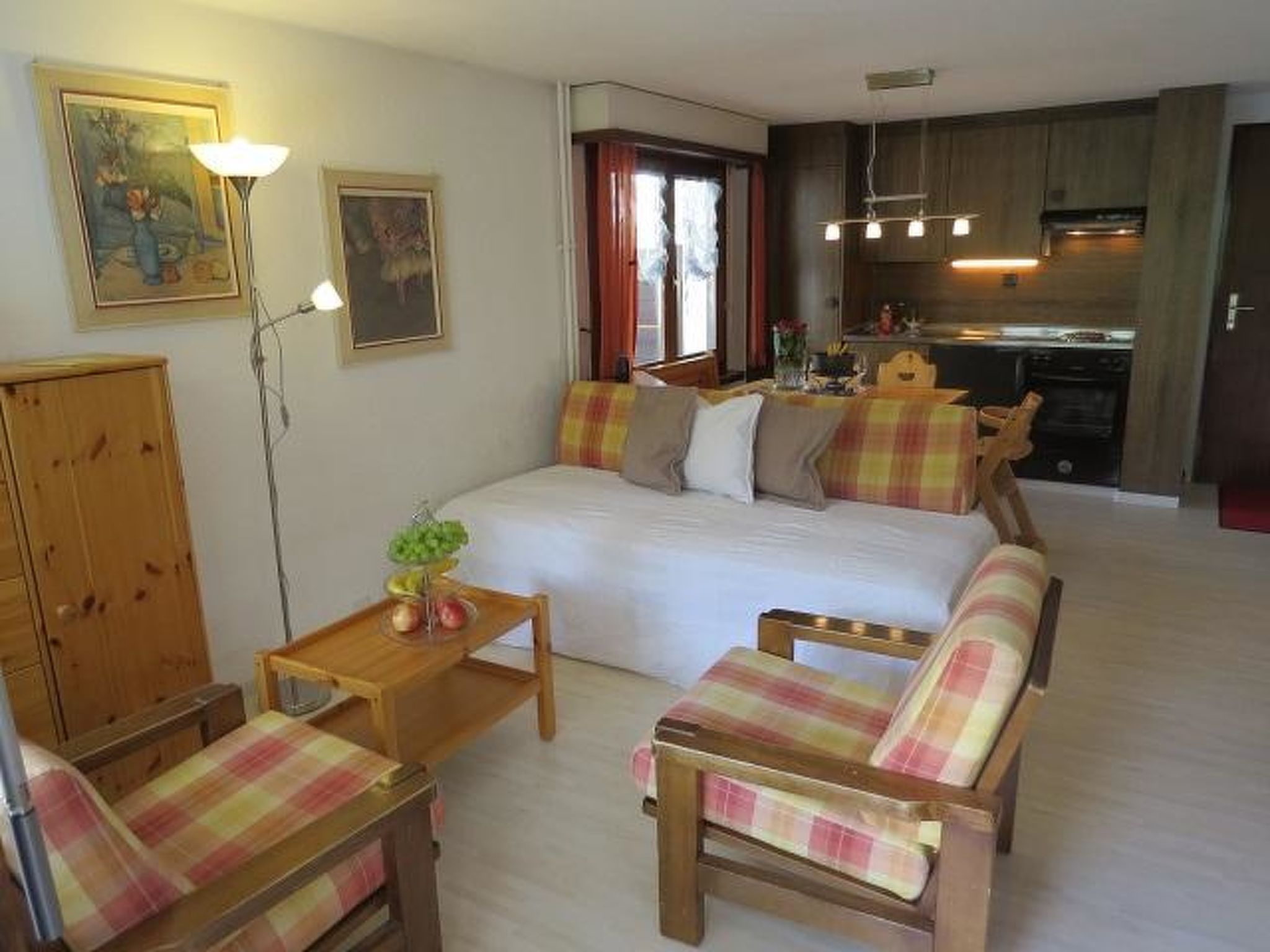 Ein gemütliches Schlafzimmer mit einem Bett, zwei Stühlen, einem Nachttisch und einem Holzschrank.