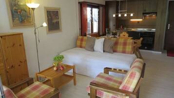 Ein gemütliches Schlafzimmer mit einem Bett, zwei Stühlen, einem Nachttisch und einem Holzschrank.