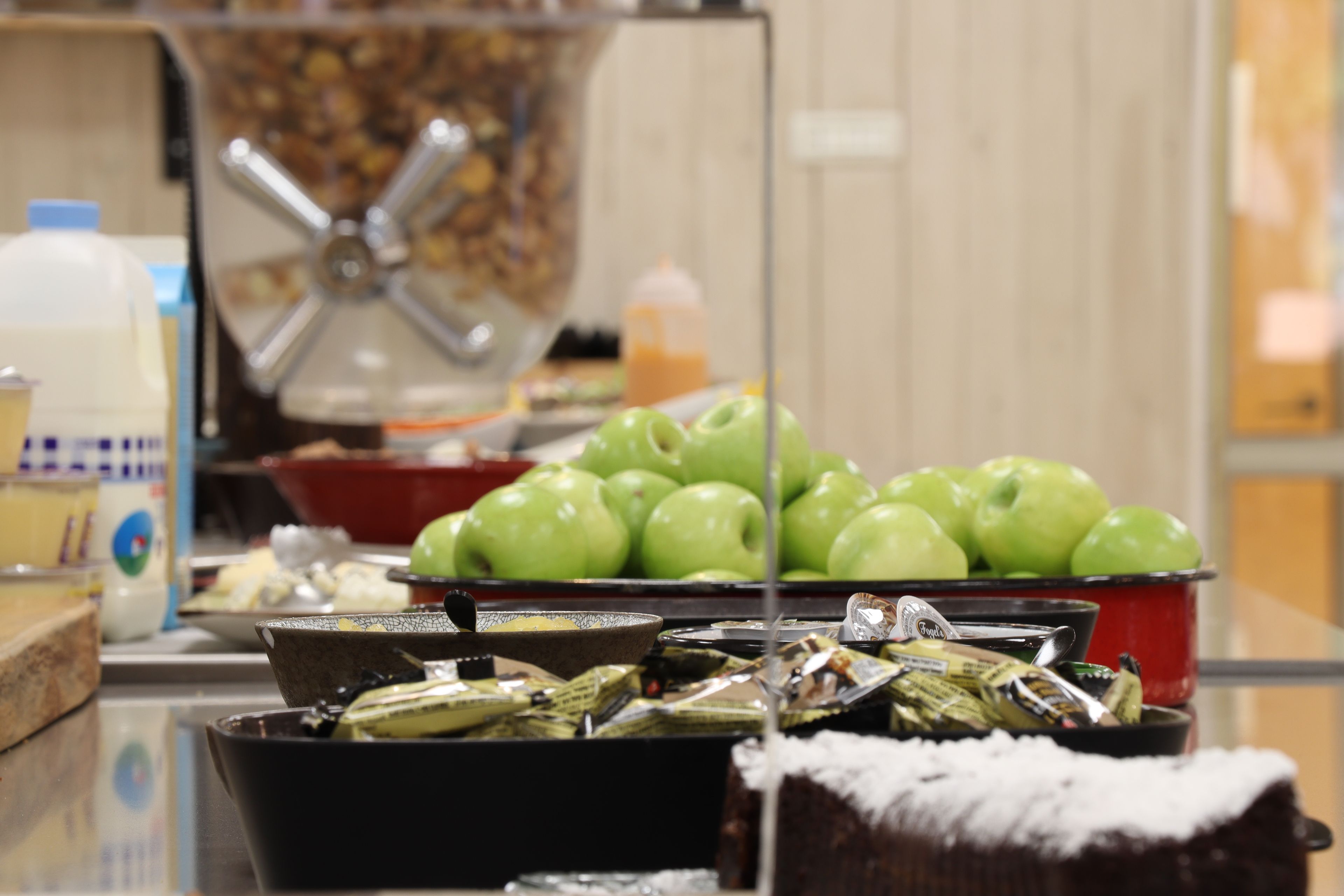 A kitchen counter with various food items, including green apples and packaged goods.
