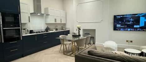 A modern kitchen with built-in appliances and a dining area with a table and chairs.