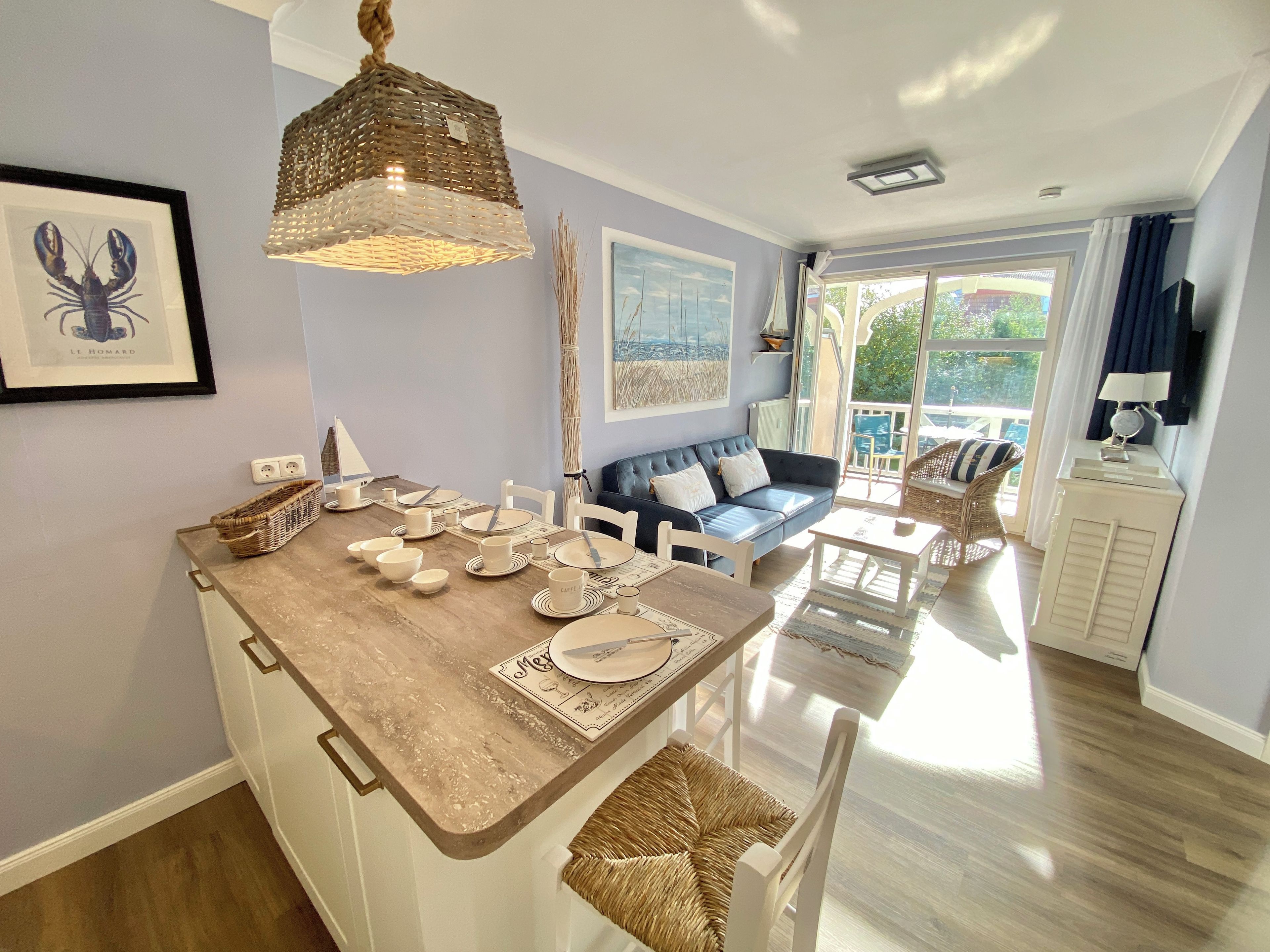 Una habitación luminosa con zona de comedor, un sofá y vistas al exterior.