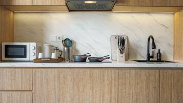 A modern kitchen with a built-in microwave, kettle, toaster, and sink.